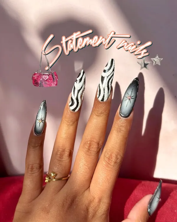 Statement nails featuring a bold zebra print and airbrushed star accents. This is for when you want to stand out.