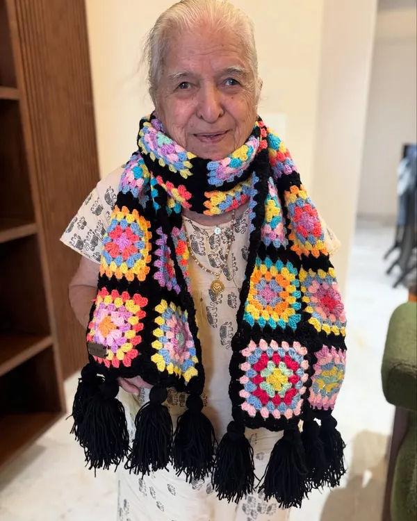 A classic granny square muffler with a bold black border that makes the colors pop. This design is a timeless favorite, finished with matching black tassels for a playful touch.