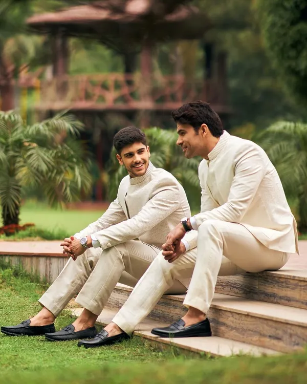 The groom's tribe in coordinated ivory and paisley Jodhpuri suits. This candid shot captures the camaraderie and style of the groomsmen, perfectly dressed for a summer wedding.