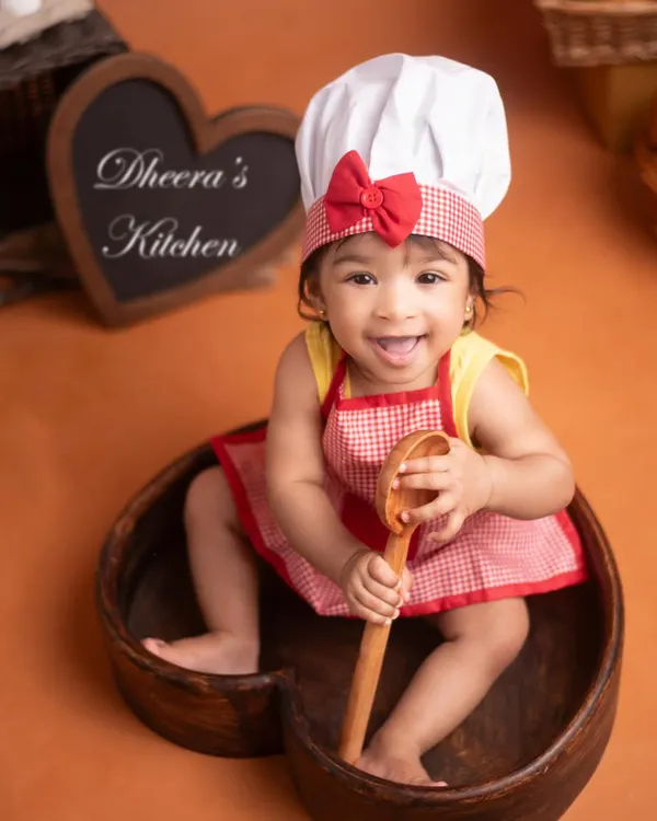 Welcome to the 'Little Chef' kitchen! This is such a fun theme for a sitter milestone or half-birthday shoot. This baby girl's cheeky smile and playful pose with the wooden spoon say it all.
