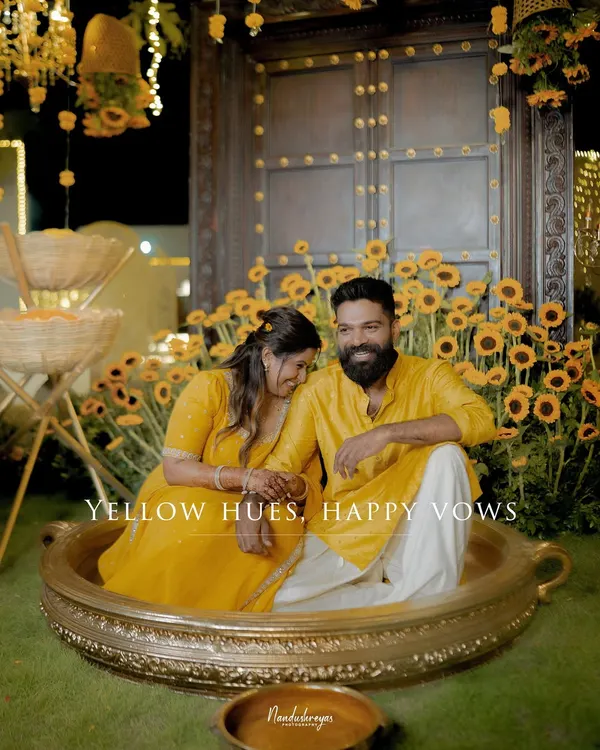 A sweet, posed moment before the Haldi fun begins. The sunflower decor and yellow outfits create a perfectly coordinated, joyful scene.