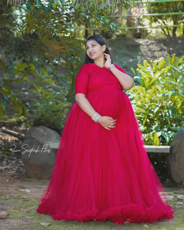 This simple yet stunning red flowy gown is perfect for a classic maternity portrait. The full tulle skirt provides a beautiful shape and a pop of color in a serene garden setting.