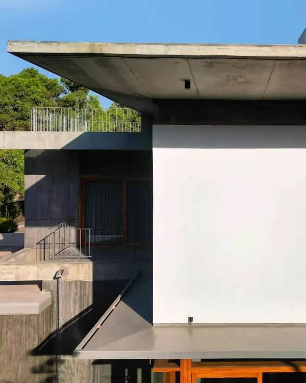 Cascading cantilevered concrete roofs define the form of the House of Canopies. These strong horizontal planes create layered, sheltered spaces below, from open terraces to shaded verandahs, extending the living areas into the landscape.
