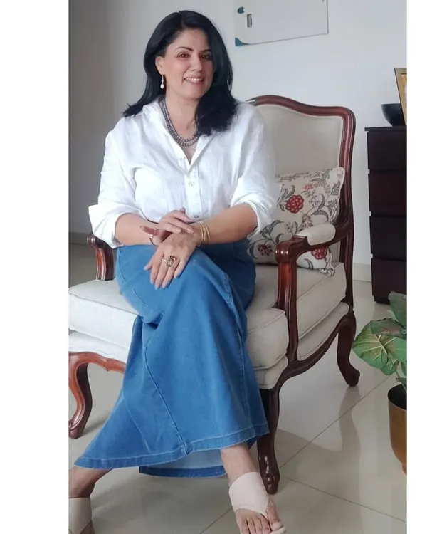 A seated pose in my classic white linen shirt and denim skirt, a perfect outfit for celebrating a 30-year friendship.