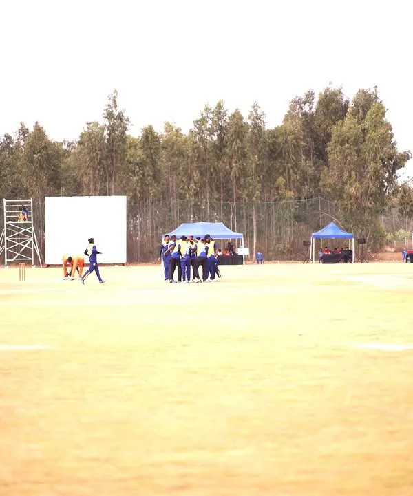 A wide shot of the Indian Corporate Cricket League, showcasing the full event setup with multiple pitches, player tents, and spectator areas, all managed by our team.