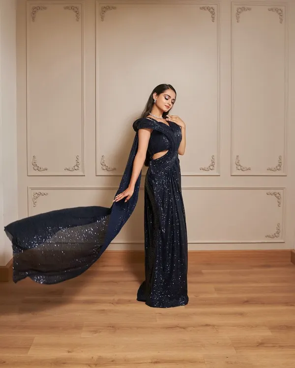 Our Glamour gown is a showstopper. This navy blue sequined dress features a thigh-high slit and a dramatic, flowing trail for a red-carpet-worthy look.
