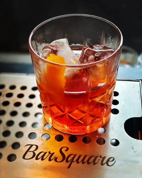 Crafting a perfect Negroni on our custom Bar Square drip tray. This cocktail represents the classic, balanced approach we bring to menu development.