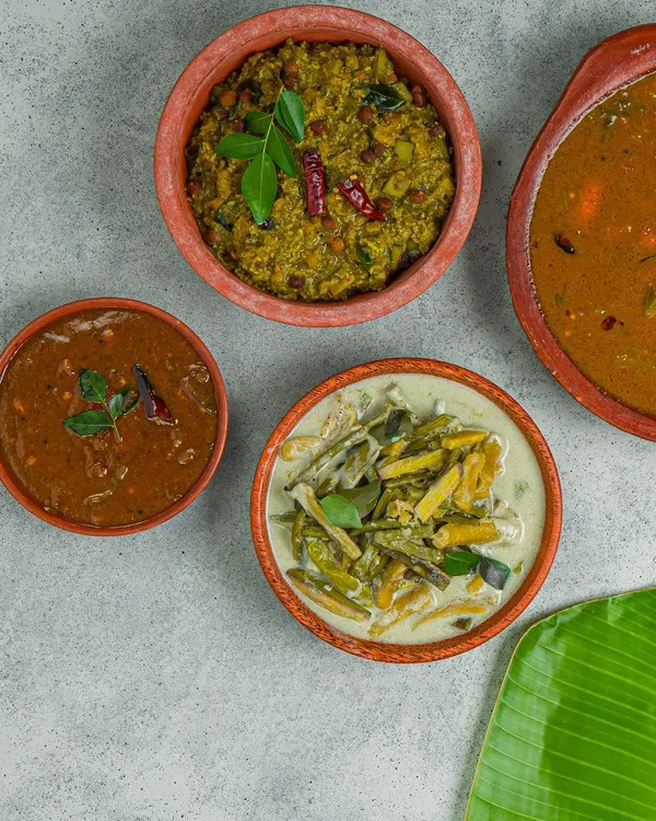 A comforting spread of South Indian curries, including a flavorful sambar, a coconut-based kootu, and a tangy rasam. Each dish is prepared using traditional family recipes and the freshest ingredients available.