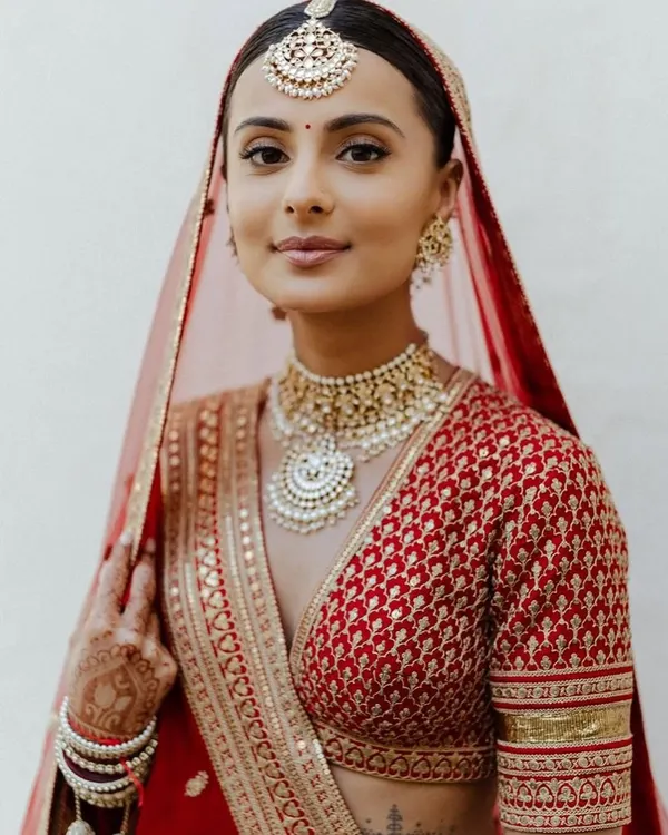 This breathtaking bride in a red Sabyasachi lehenga is a perfect example of a classic look. You'll learn to create this clean, elegant makeup with a focus on flawless skin.