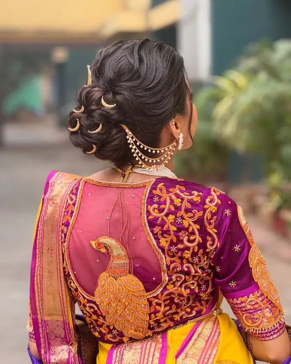 A detailed look at a traditional Maharashtrian bridal bun. I used crescent moon shaped pins and a chained accessory to create an authentic and regal look that beautifully complements the bride's Paithani saree.