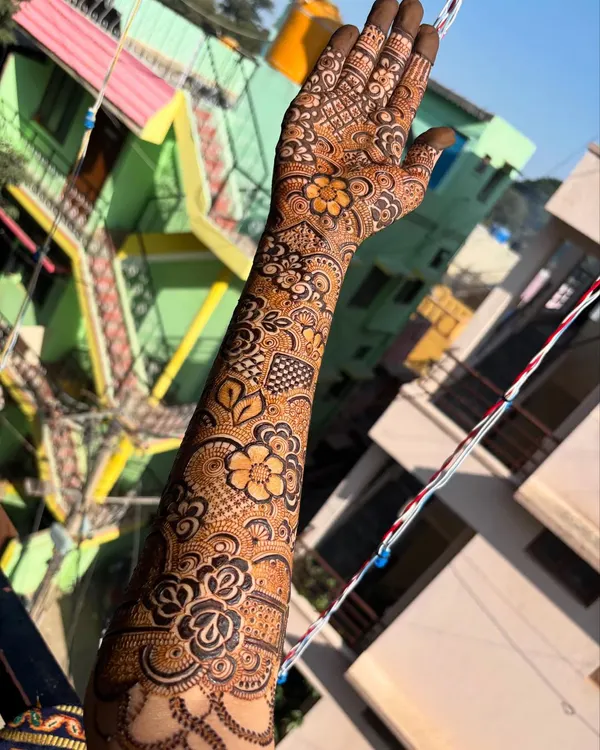A beautiful floral arm design captured in the sunlight, showing the rich color and intricate details of the flowers and leaves.