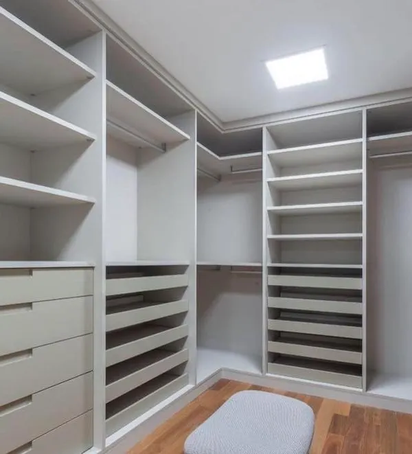 This image showcases the internal configuration of a custom walk-in closet before the doors are installed. Notice the variety of storage options, including pull-out shoe racks, deep drawers, and double hanging rods, all designed to the client's specifications.