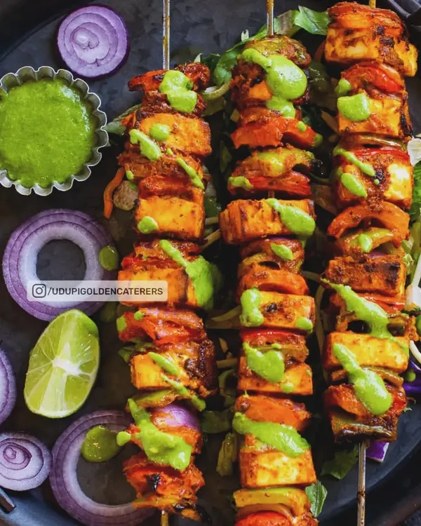 Skewers of colorful Paneer Tikka, featuring marinated cottage cheese, bell peppers, and onions. Grilled live at your event, these starters are served hot with a drizzle of mint chutney for a burst of fresh flavor.