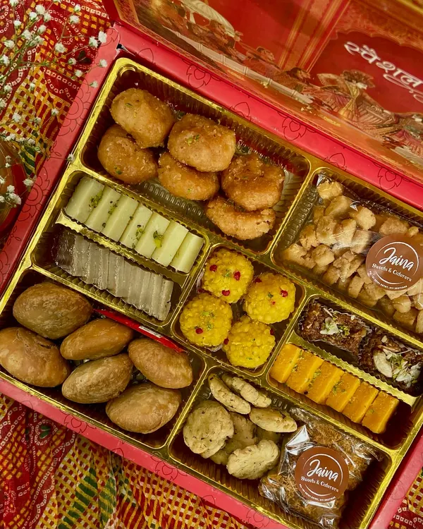 This is our fancy Bhaji Box, perfect for the Indian wedding season. It's packed with a variety of traditional sweets and savouries, including mathri, laddoos, and barfi, all arranged beautifully for gifting.