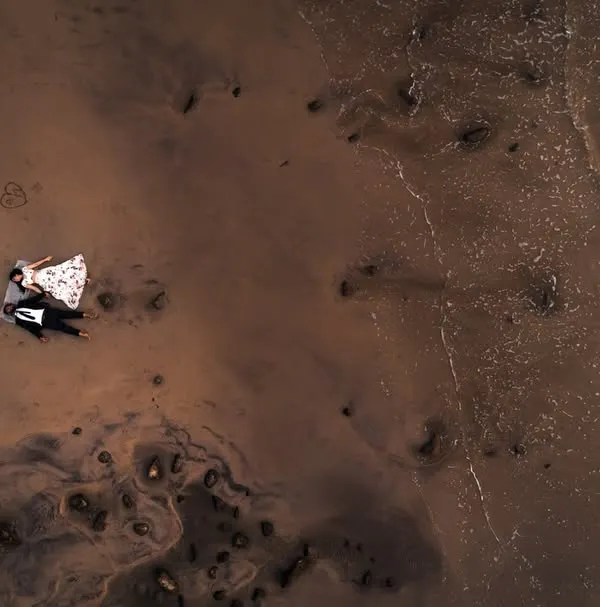 An aerial drone shot of Pulak and Manasi, finding stillness together as the waves kiss the shore. A truly epic perspective on a beach romance.