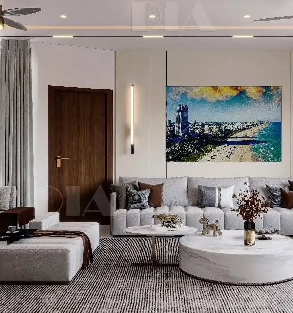 A showcase of contemporary living room design, featuring a large sectional sofa, a round marble center table, and carefully placed accent lighting. The space is designed to feel luxurious, warm, and calming.