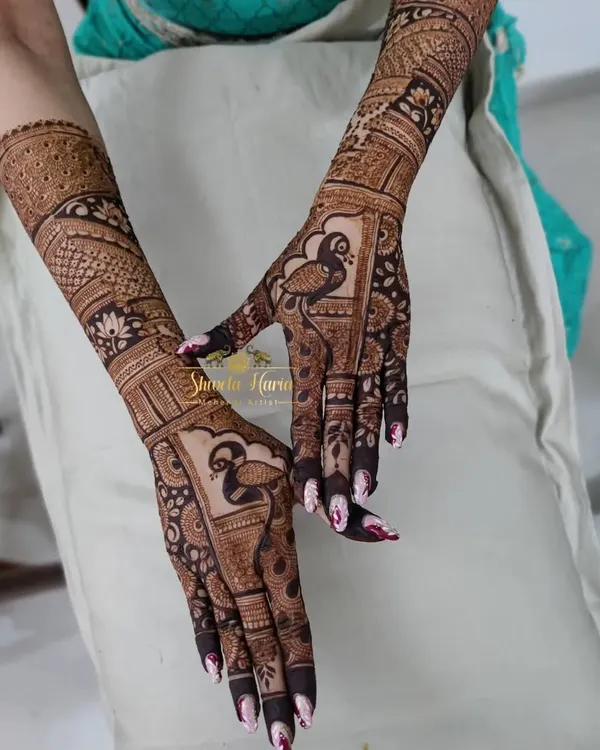 A heavy Indian back-hand design perfect for a bridesmaid, featuring bold peacocks and intricate fill-work that extends up the arm.
