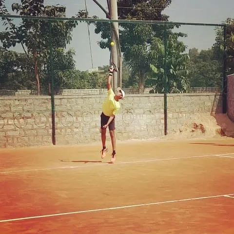 A junior player executes a powerful jump serve, showcasing the high level of athleticism and technique developed and displayed at my tournaments.