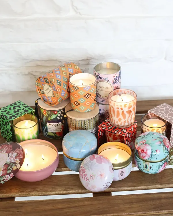 A beautiful assortment of our scented candles, showcasing the wide variety of designs we offer. From vibrant printed tins to elegant glass jars, there is a Panos candle to suit every style and mood.