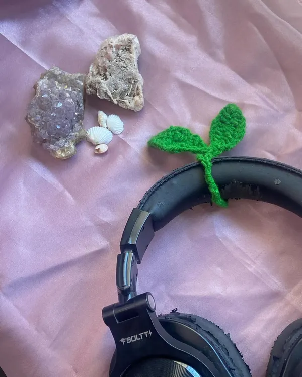 This is my little leaf sprout tie wrapped around a pair of headphones. I love using them to keep my cords from getting tangled, but they also work as a bookmark!