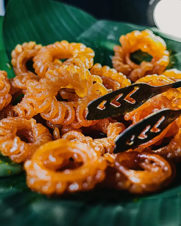 Taking the phrase "kuch meetha ho jaaye" very seriously. A platter of hot, crispy imartis, a classic Indian sweet, served fresh on a banana leaf for an authentic touch.