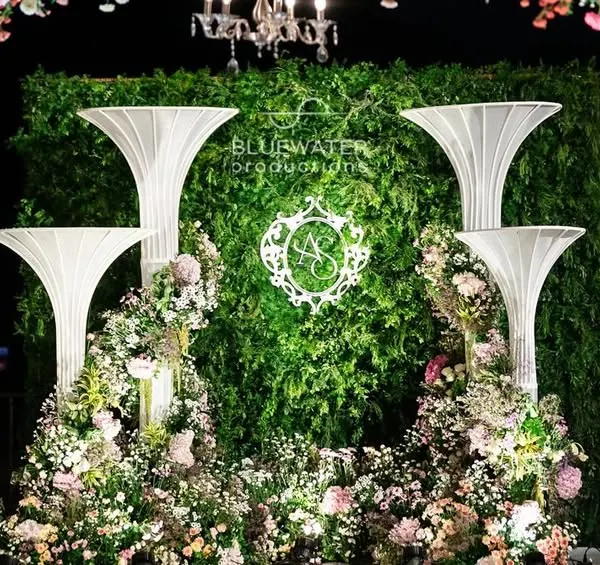 A detail of the floral and sculptural elements at the 'Blue Palace' reception, featuring a custom monogram against a living green wall.