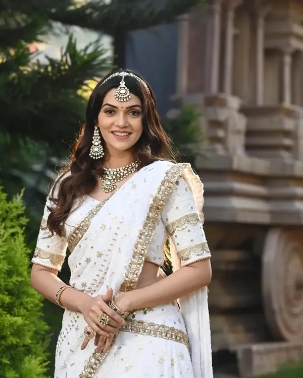 An angelic look in white! This celebrity client is wearing a beautiful Kundan choker and matching earrings that perfectly complement her elegant white lehenga.