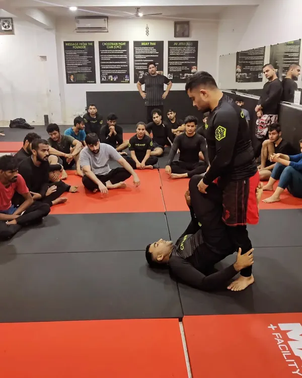 A coach provides one on one instruction for a student drilling a guard pass. We believe in giving personalized feedback to ensure every member understands the technique correctly.