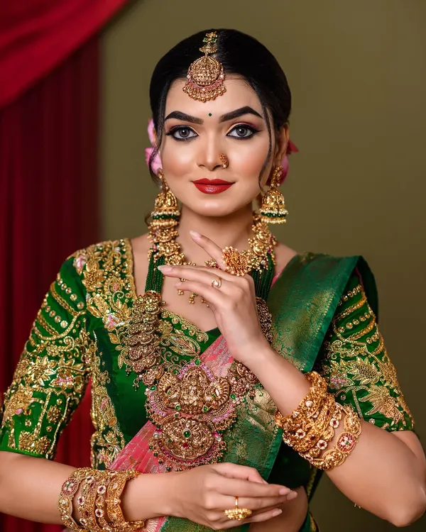 A timeless South Indian bridal look, complete with intricate temple jewellery and a bold red lip. We focus on creating a radiant, flawless base that enhances your natural beauty for the muhurtham ceremony.