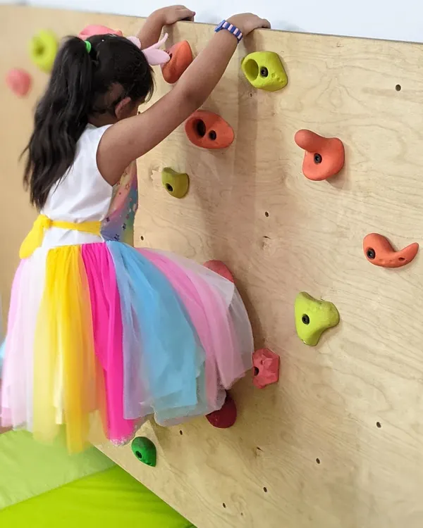 Dressed for a party but still ready to climb. Our indoor climbing wall is a safe and exciting way for children to build strength, coordination, and confidence as they plan their route to the top.