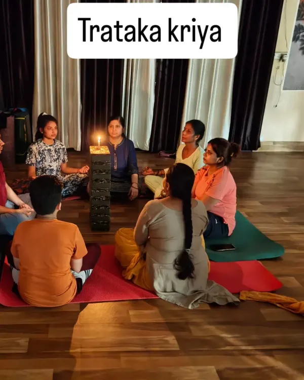 A group of students gathered for Trataka Kriya (candle gazing). The focused gaze on the flame helps to steady the mind, cleanse the eyes, and activate the Ajna Chakra, or third eye.