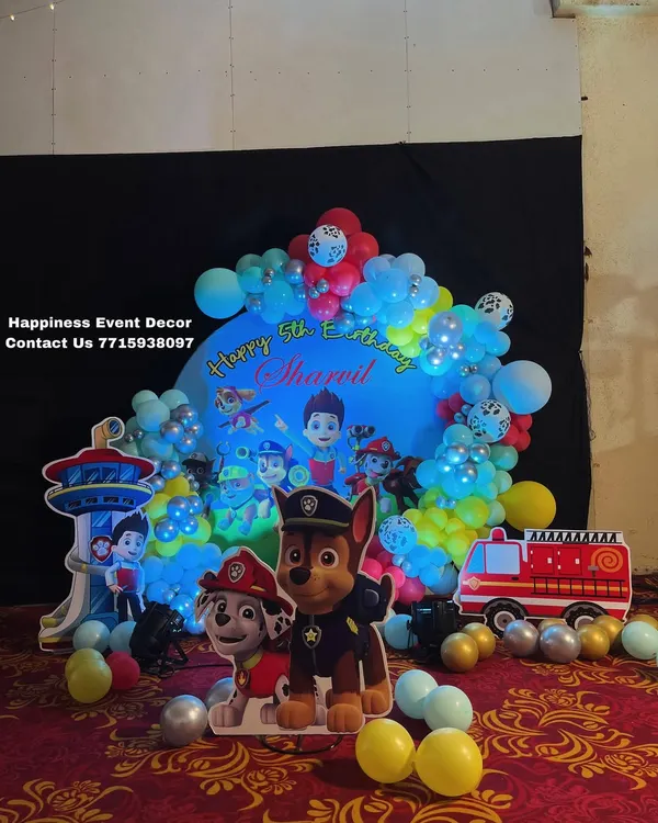 A complete Paw Patrol theme decoration for a 5th birthday. This setup includes a circular backdrop, character cutouts of Chase and Marshall, and other elements like the lookout tower.