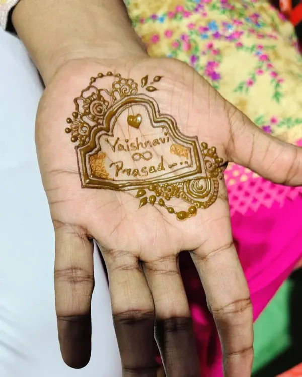 A simple yet meaningful design for a groom, featuring the couple's names, Vaishnavi and Prasad, inside an ornate frame. It's a sweet and personal touch.