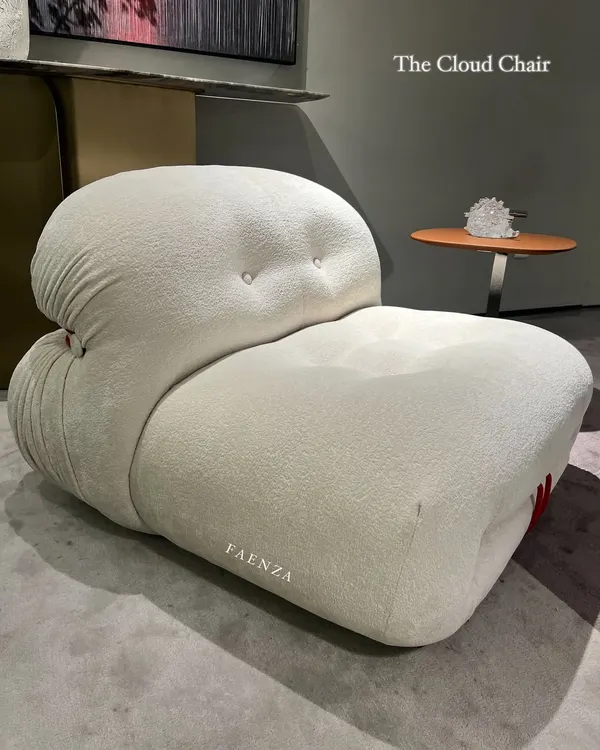 The Cloud Chair, an iconic piece designed for ultimate comfort. Upholstered in a soft, textured bouclé fabric, its billowy, low-slung form invites you to sink in and relax.