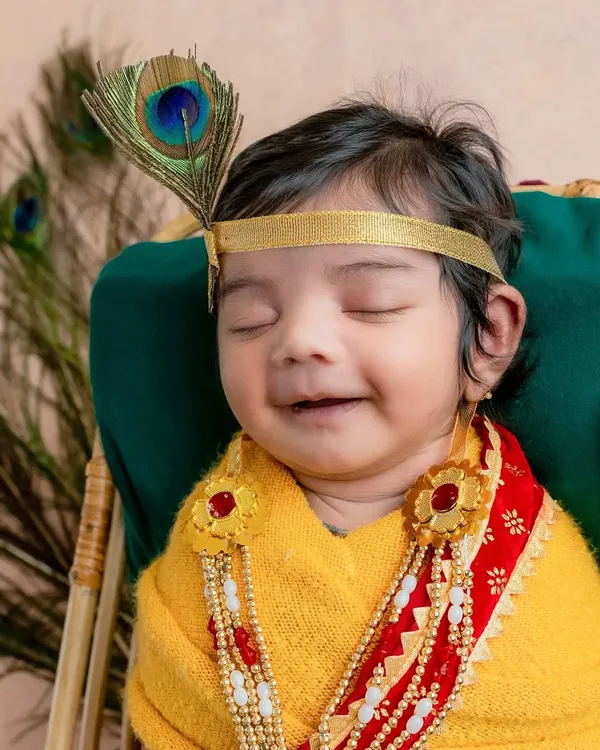 My heart melts seeing a baby dressed as Natkhat Krishna. This little one's peaceful smile, complete with a peacock feather, captures the divine and playful spirit of the theme.