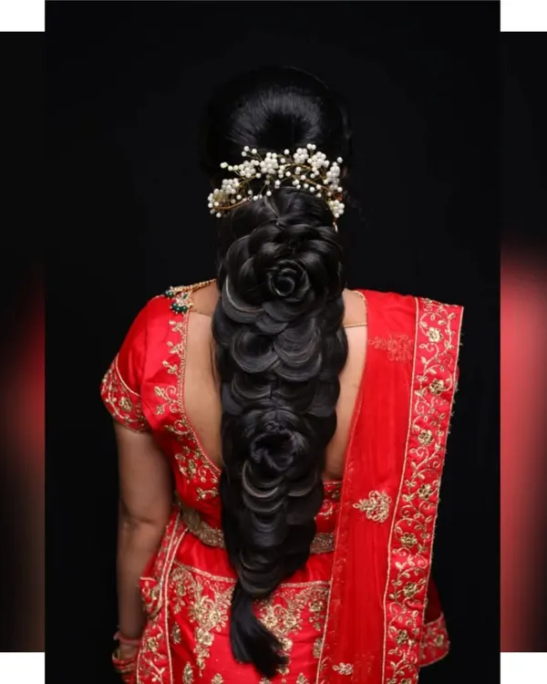 A stunning example of an intricate bridal braid. This hairstyle features multiple rose-shaped buns woven into the braid, creating a unique and highly detailed look for a bride.