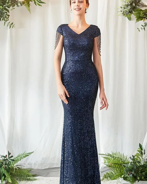 Look effortlessly chic at your next reception or formal event in this navy blue sequin gown. The figure-hugging silhouette and delicate tassel details on the shoulders add a touch of modern glamour.