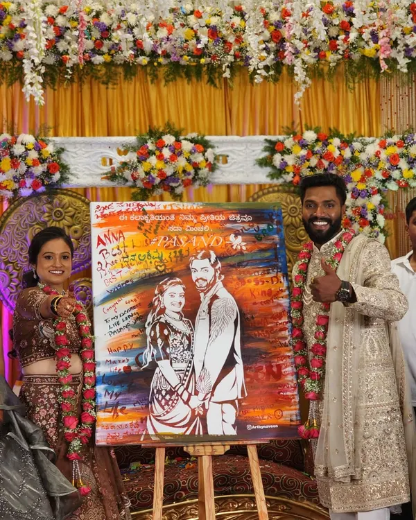 The final reveal is always a magical moment. This couple's smiles say it all as they hold their finished live wedding painting, complete with signatures and messages from their loved ones.
