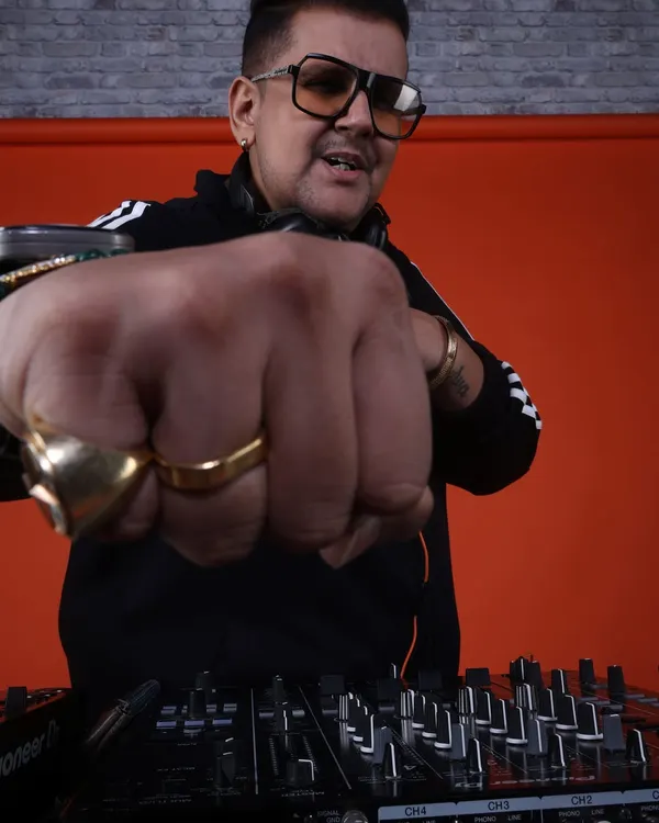Bringing the energy right to you. This is my signature pose, reaching out to the crowd from behind the console. It's all about connection, energy, and making you a part of the show.