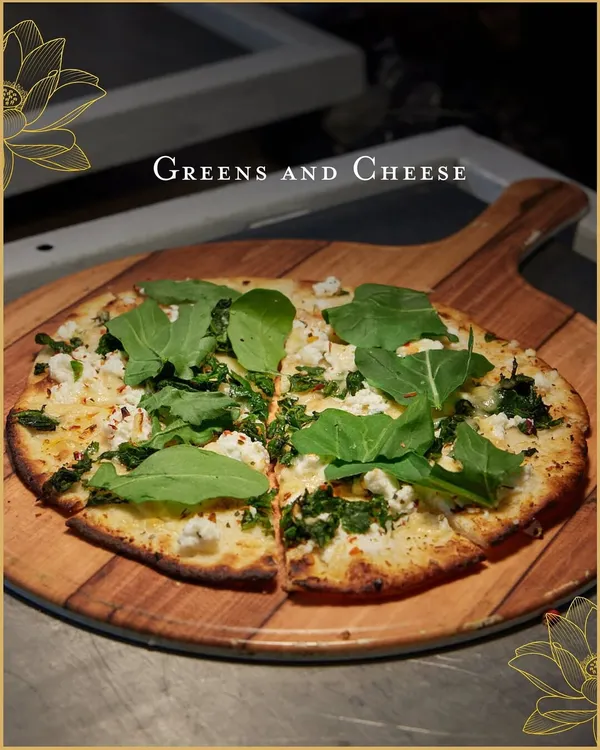 Our live-baked pizzas are always a hit. This one, topped with fresh arugula and crumbled cheese, showcases our commitment to using quality ingredients for a superior taste.