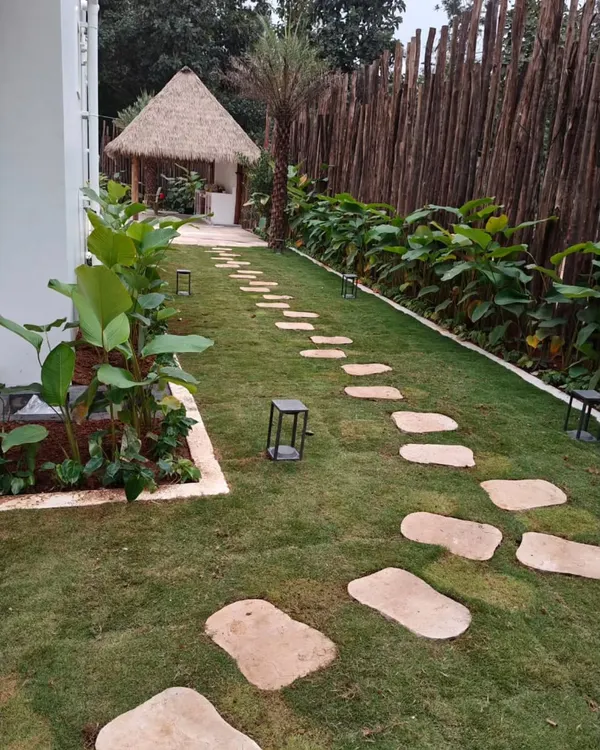 A perfect example of a finished garden featuring a healthy lawn, a winding stone path, and a rustic gazebo. The design creates a peaceful retreat right in the backyard.